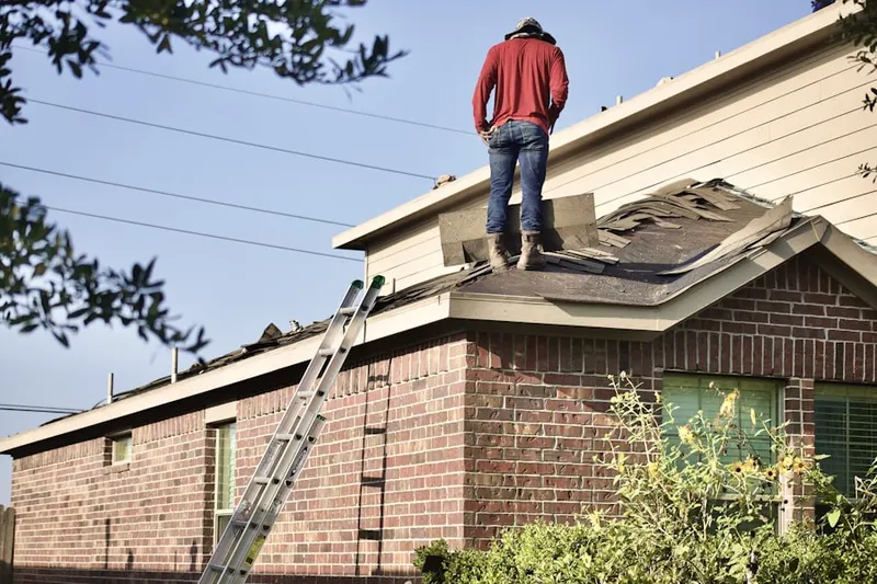 Professional roofer working on a residential roof in Vose